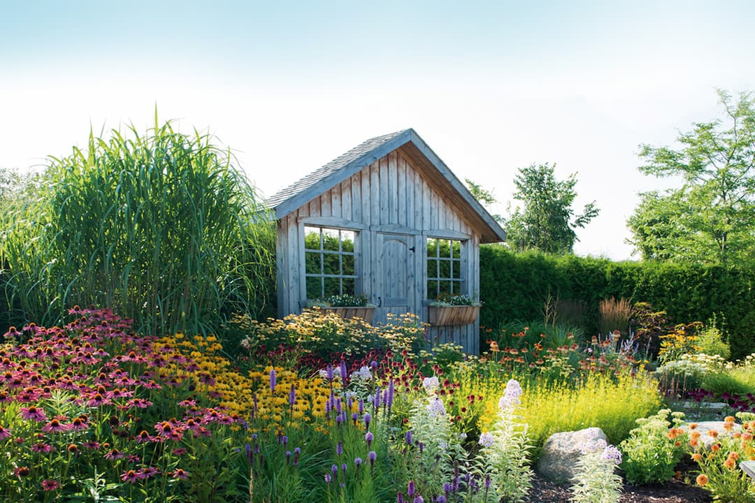 Maison en bois dans un jardin de fleurs