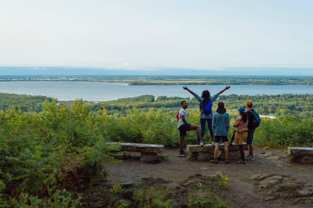 Groupe de personnes en haut du Clavaire d'Oka avec vue sur le lac des Deux-Montagnes