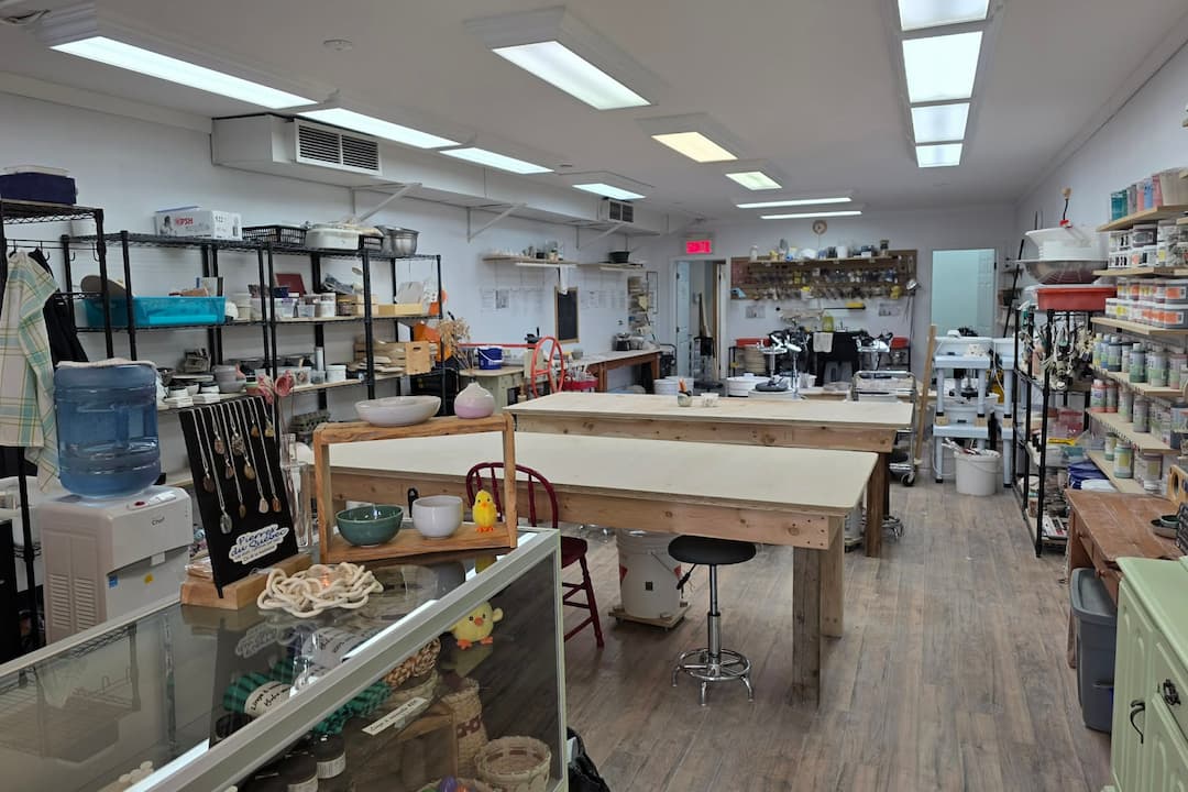 Vue sur l'atelier de poterie, longues tables de travail
