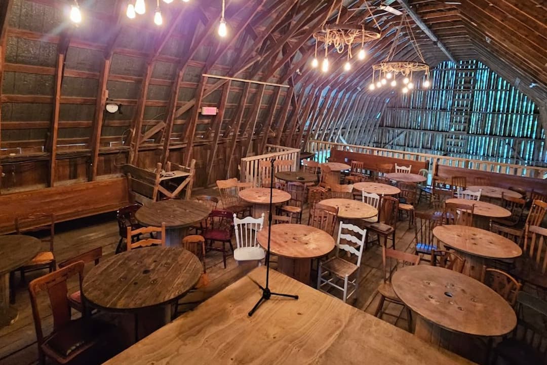 Salle de spectacle ou stand up avec tables et chaises en bois