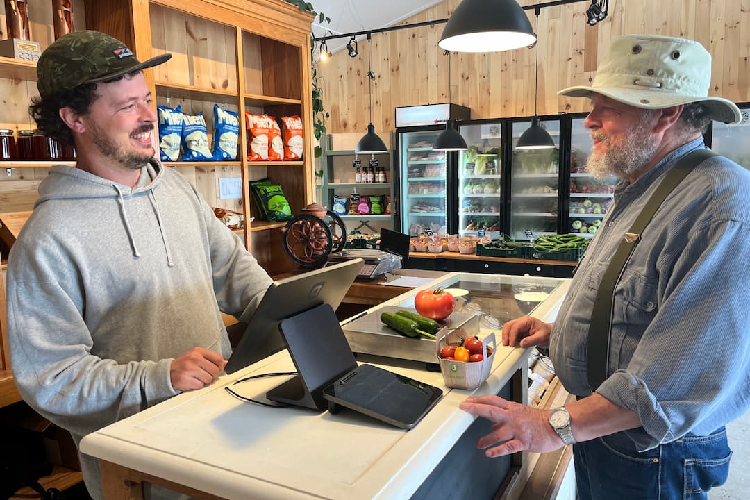 Client et caissier souriant en train de passer une transaction, achat de légumes frais de la ferme